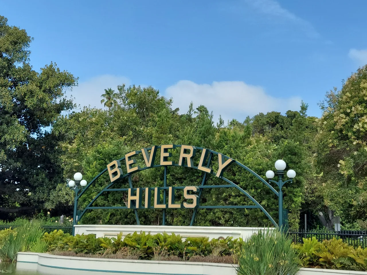 Beverly Hills sign surrounded by trees and gardens in Beverly Gardens Park, California